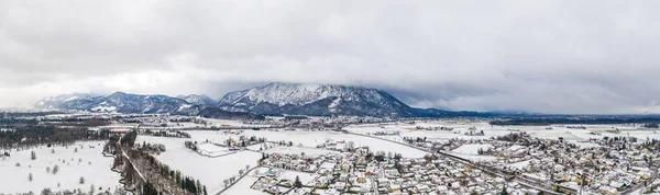 前景のアウトスカートにアニフ雪村と霧の中でオーストリアの山の半分のパノラマの空中ビュー — ストック写真