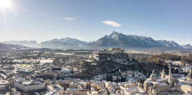 Karlı Hohensalzburg kalesinin panoramik hava aracı görüntüsü. Kış sabahı Unesberg Dağı manzaralı.