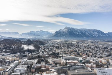 Salzburg Aiglhof İstasyonu 'nun kışın karlı Alp Dağları manzaralı hava aracı görüntüsü.