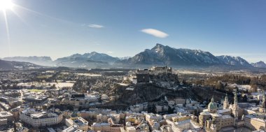 Karlı Hohensalzburg kalesinin panoramik hava aracı görüntüsü. Kış sabahı Unesberg Dağı manzaralı.