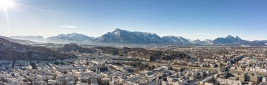Kış sabahı Unesberg Dağı manzaralı Salzburg 'un karlı kuzey kasabasının insansız hava aracı görüntüsü
