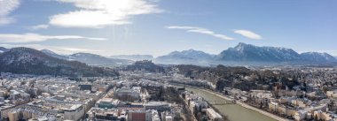Hohensalzburg kalesi Unesberg 'in kış sabahı manzaralı eski Salzburg karlı kasabasının panoramik hava aracı görüntüsü.