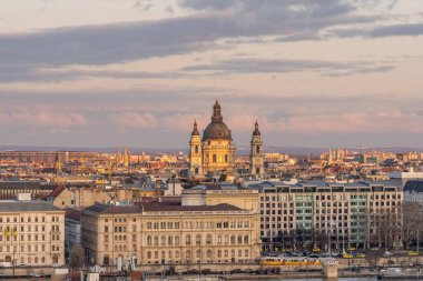 Tuna nehri manzaralı St. Stephen Bazilikası altın gün batımı saatinde sarı tramvay arabasıyla kışın