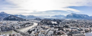 Kış sabahı Hohensalzburg kalesi Unesberg manzaralı Salzburg 'un karlı ve eski kasabasının panoramik hava aracı görüntüsü