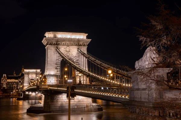 Szechenyi chain bridge with lights on in Budapest evening in winter time