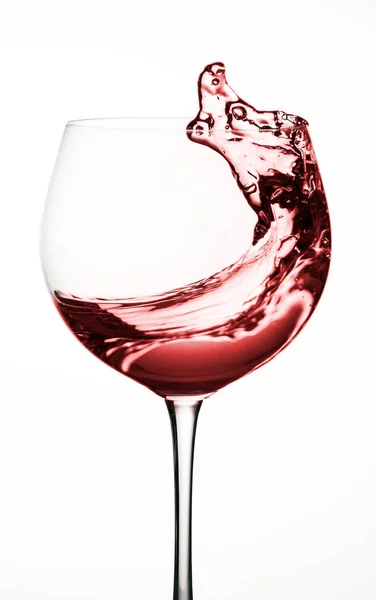 Bicchiere da vino, spruzzata di acqua rossa su fondo bianco isolato . — Foto Stock