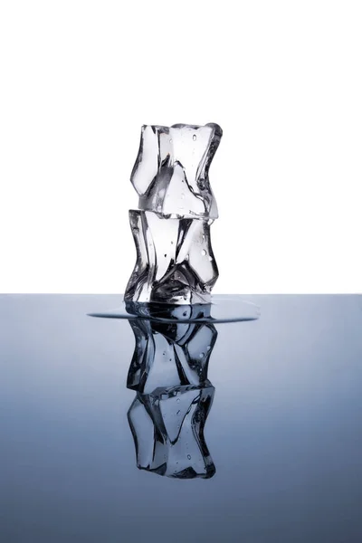 两个冰块的水滴在白色和蓝色的背景下被隔离 — 图库照片