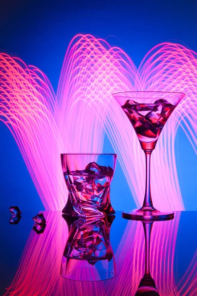Два келихи коктейль Martini віскі лід, на синьому фоні красивих світлових ефектів . — стокове фото