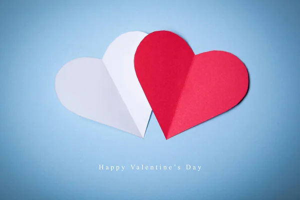 Happy Valentines day, Red and White Hearts from paper on blue background. Good Holiday Card.