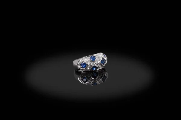 Silberner Edelring weiblich mit Diamanten und Saphir auf schwarzem Hintergrund. gutes Material für Designschmuck. — Stockfoto