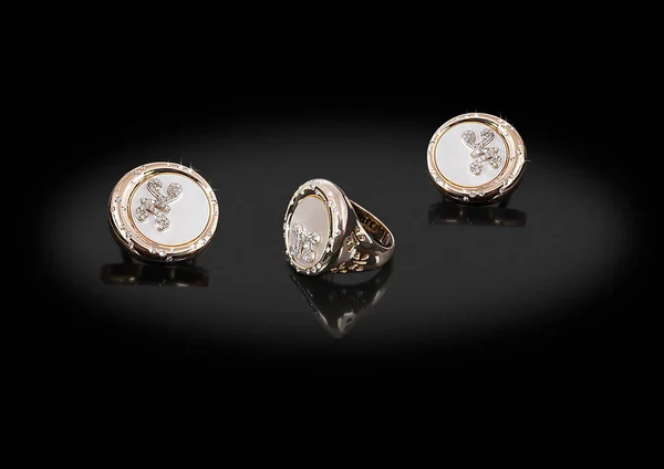 Kerek arany értékes fülbevaló gyűrű gyöngyház gyémánt és a pillangó a fekete háttér. — Stock Fotó