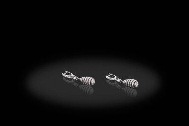 Siyah arka plan üzerine Pırlantalı gümüş değerli küpe.