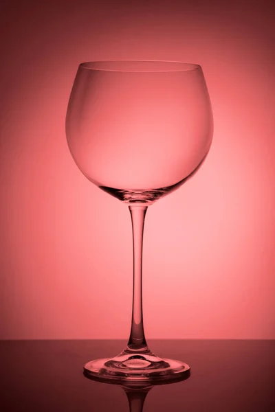 Grande bicchiere vuoto per vino rosso su sfondo sfumato rosa . — Foto Stock