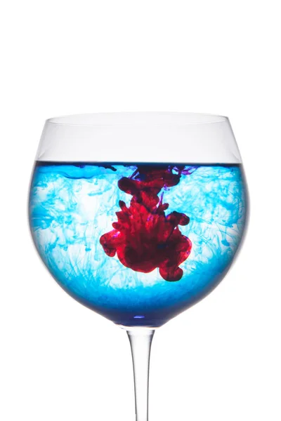 Lebensmittelfarbe diffus in Wasser im Weinglasbereich für Slogan oder Werbe-SMS, isolierter weißer Hintergrund. — Stockfoto