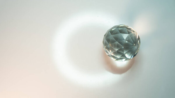 Large crystal on a white background with light refraction abstraction. A lot of space for an inscription or logo.