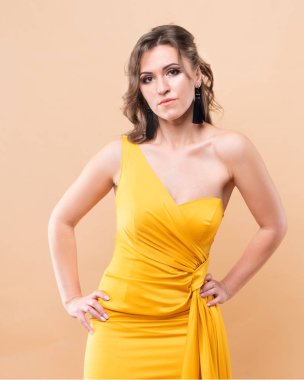 Kahverengi saçlı, güzel yüzlü, sıska, bronz tenli güzel kadın. Moda elbisesi giyin. Moda elbisesi, ipek, podyum modeli..