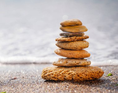 Kum üzerindeki taş piramit zen, ahenk ve dengeyi sembolize eder. Pozitif enerji. Arkaplanda okyanus