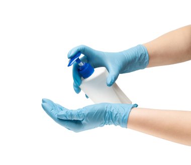 Mavi renkli koruyucu lastik eldivenli kadın elleri bakterilere karşı savaşmak için bir şişe plastik antiseptik tutuyor. Beyaz arkaplanda izole et.