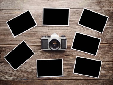 Boş fotoğraf çerçeveleri ile ahşap arka plan üzerinde Vintage fotoğraf makinesi