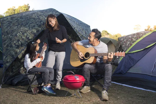 Enfant chantant avec une famille souriante sur le camping — Photo