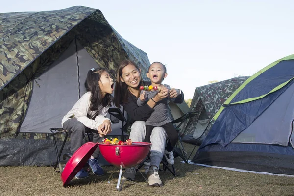 Mother and daughter barbecue on camping in nature