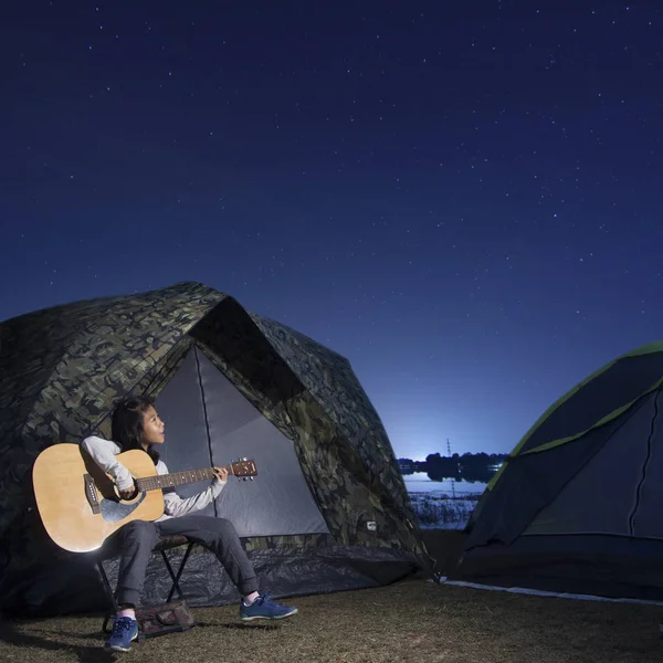 Fille jouer de la guitare à la tente brille sous un ciel étoilé nuit — Photo