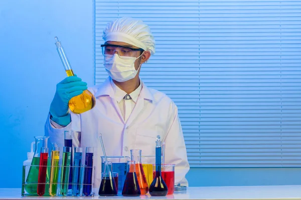 Hombre científico sosteniendo un tubo de ensayo con líquido — Foto de Stock