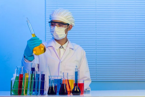 Cientista homem segurando um tubo de ensaio com líquido — Fotografia de Stock