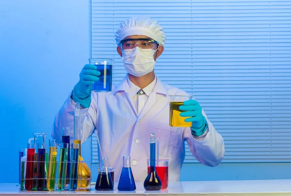 Cientista homem segurando um tubo de ensaio com líquido — Fotografia de Stock