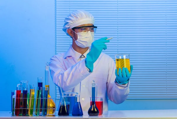 Hombre científico sosteniendo un tubo de ensayo con líquido, Con pluma de retención — Foto de Stock