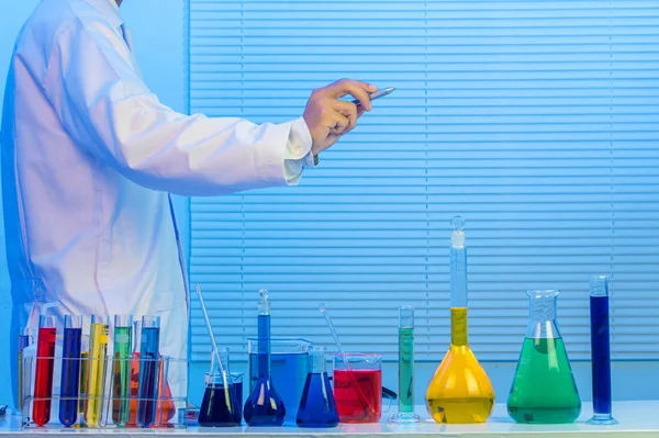 Scientist hand with pen and examine samples — Stock Photo, Image