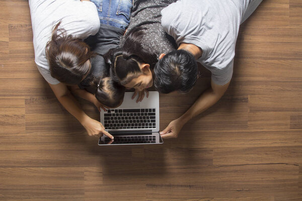 family lying on floor and using laptop 