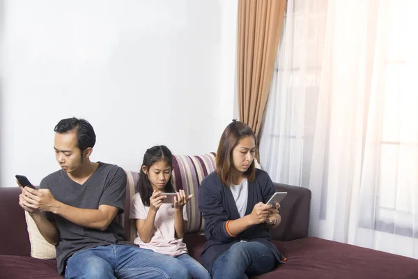 Family in living room using smartphone devices