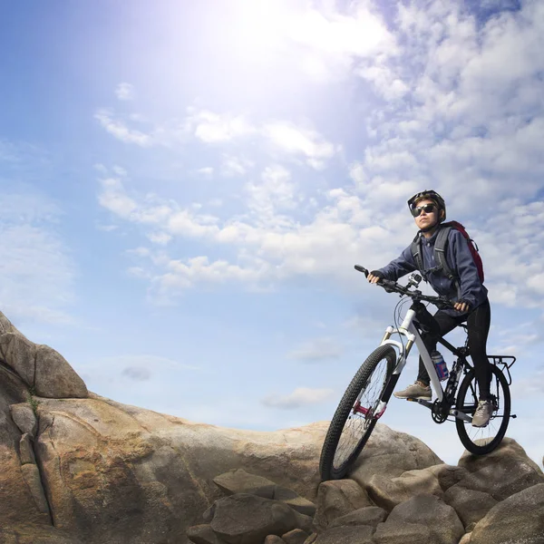 Ciclista no topo da montanha rochosa — Fotografia de Stock