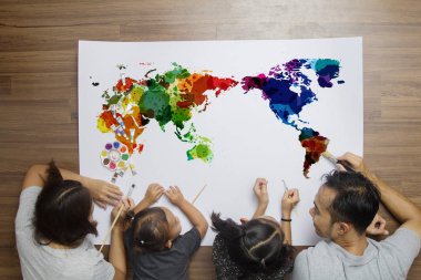 Üst görüntülemek mutlu aile yerde suluboya Dünya Haritası boyama ile yatarken 