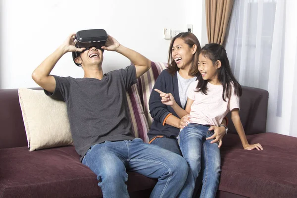 Happy asian family at home wearing virtual reality goggles