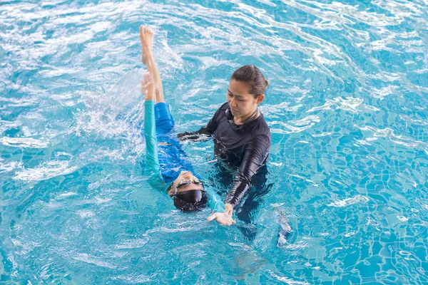Fille apprendre à nager avec l'entraîneur au centre de loisirs — Photo