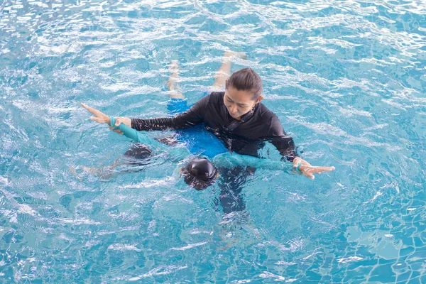Meisje leren om te zwemmen met coach in het leisure center — Stockfoto