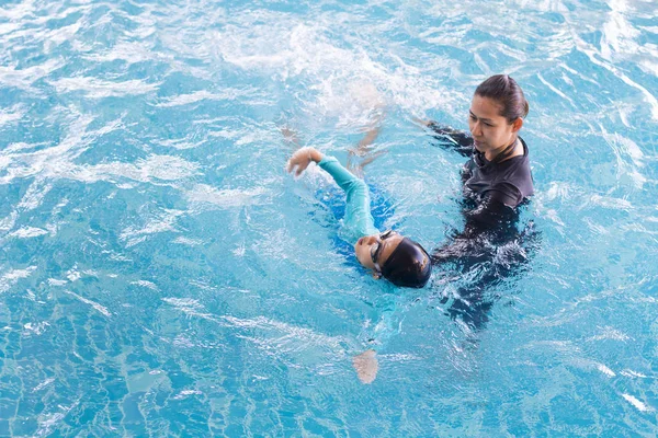 Chica aprendiendo a nadar con el entrenador en el centro de ocio —  Fotos de Stock
