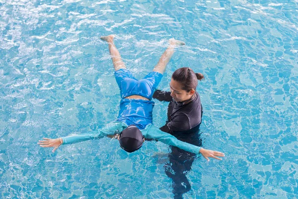 Fille apprendre à nager avec l'entraîneur au centre de loisirs — Photo