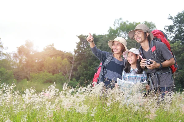 Glad asiatisk familj ryggsäck resor står nära ängen — Stockfoto