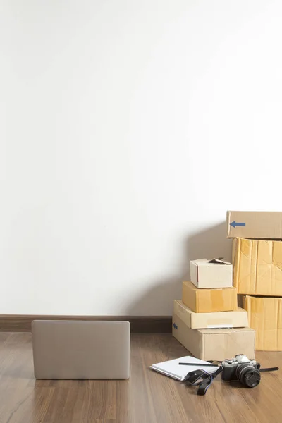 Laptop von zu Hause auf Holzboden mit Postpaket — Stockfoto