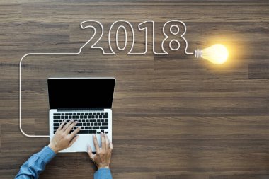 Dizüstü bilgisayarda çalışan işadamı ile yaratıcı ampul fikir 2018 yeni yıl