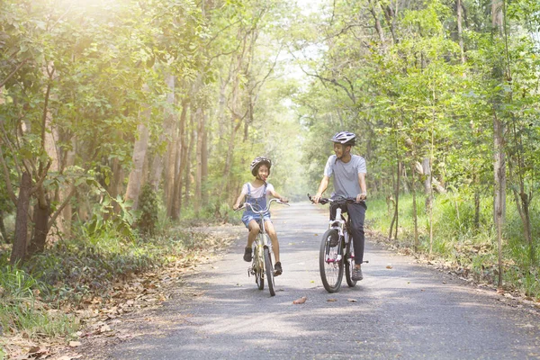 Feliz pai e filha de bicicleta no parque — Fotografia de Stock