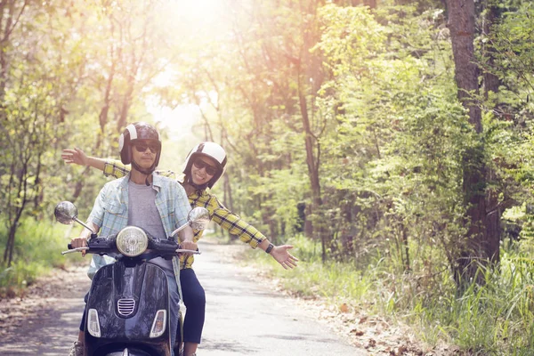 Casal montando sua scooter através da floresta. ideia de estilo de vida conc — Fotografia de Stock