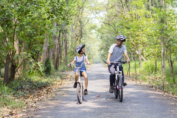 Gelukkig vader en dochter fietsen in het park — Stockfoto