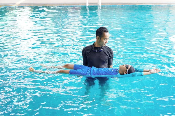 Père enseignant à sa fille à nager dans une piscine — Photo