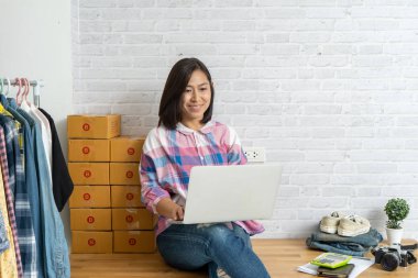 Evde dizüstü bilgisayarda çalışan Asyalı kadınlar online satış yapıyor