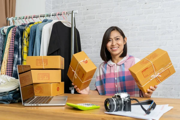 アジアの女性は、段ボール箱を保持する中小企業の所有者を起動します — ストック写真