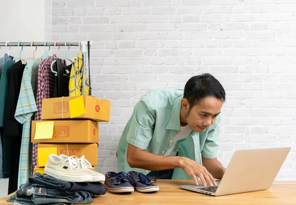 Asian man working laptop computer selling online — ストック写真